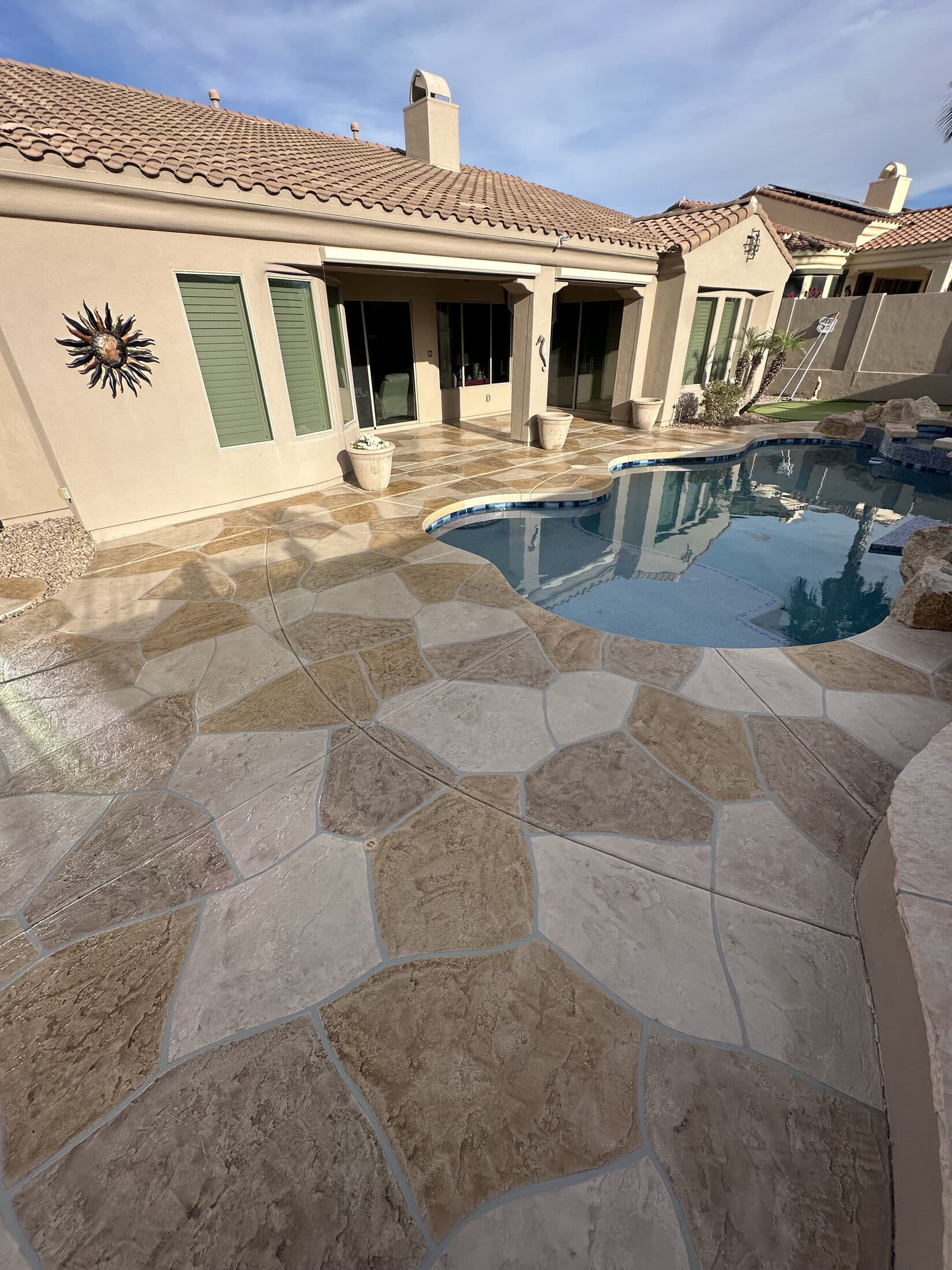 Flagstone-pattern stamped concrete overlay patio and pool deck