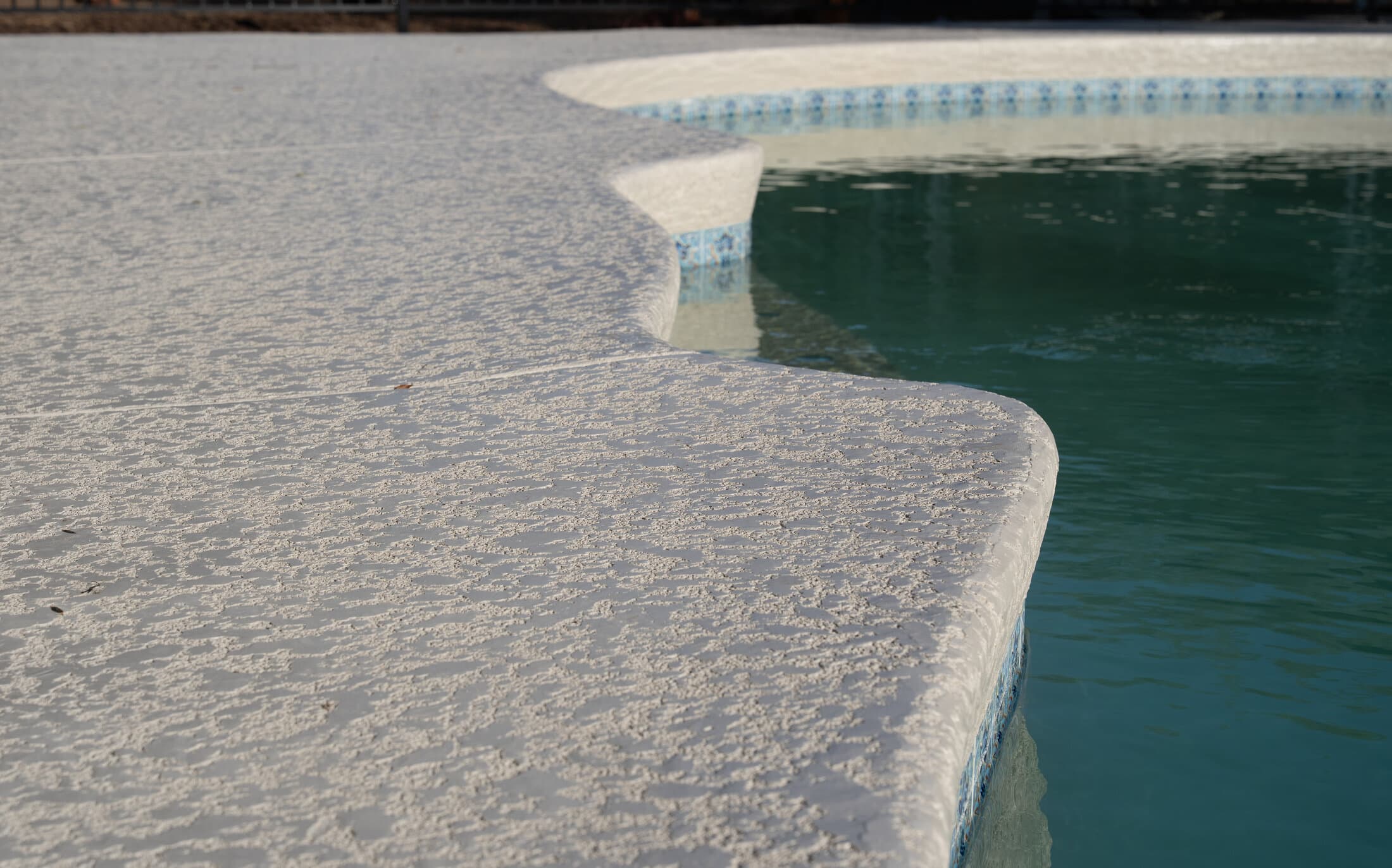 Resurfaced pool deck and coping detail in a Phoenix backyard