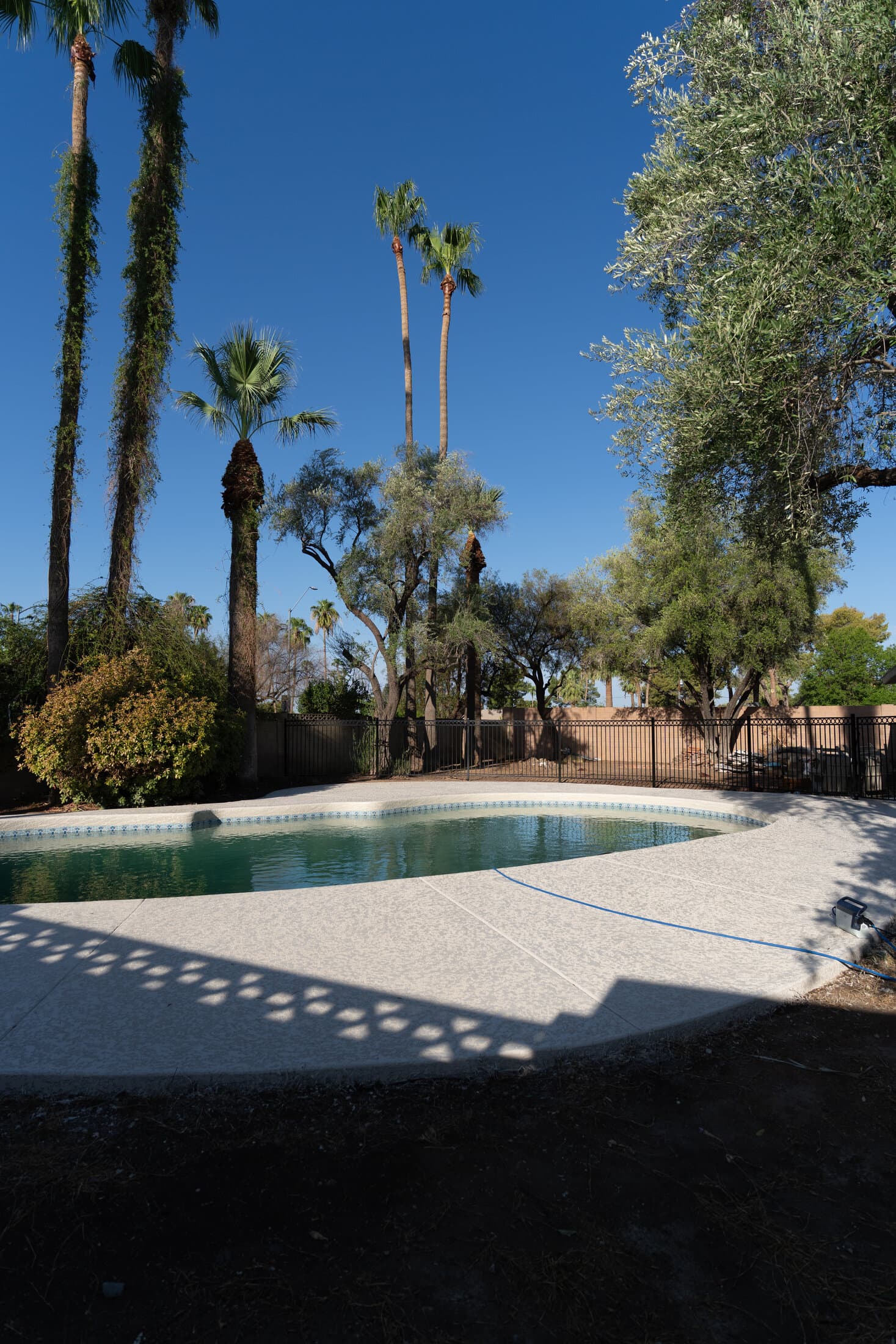 Freshly resurfaced cool deck beside a backyard pool