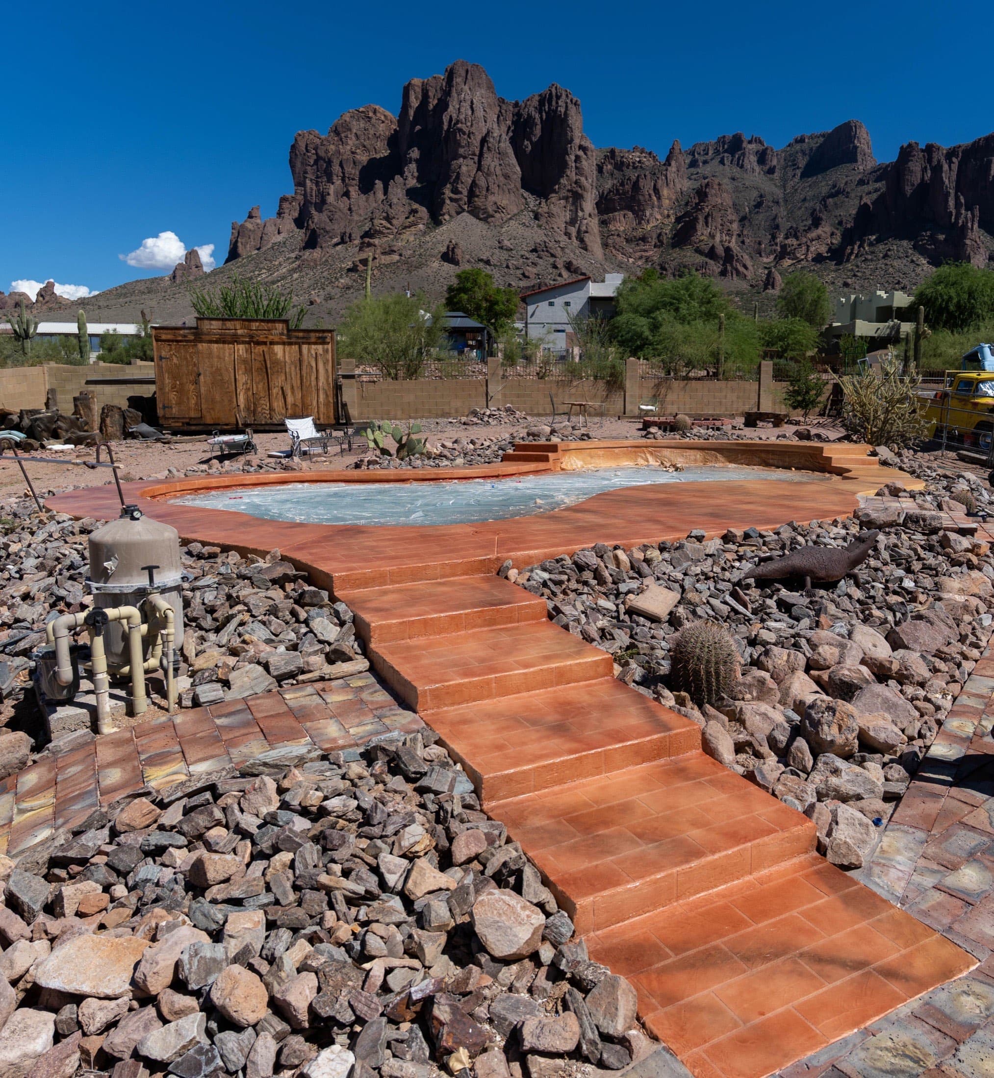 Completed pool deck resurfacing in terracotta with tile-scored steps and walkway below the Superstition Mountains