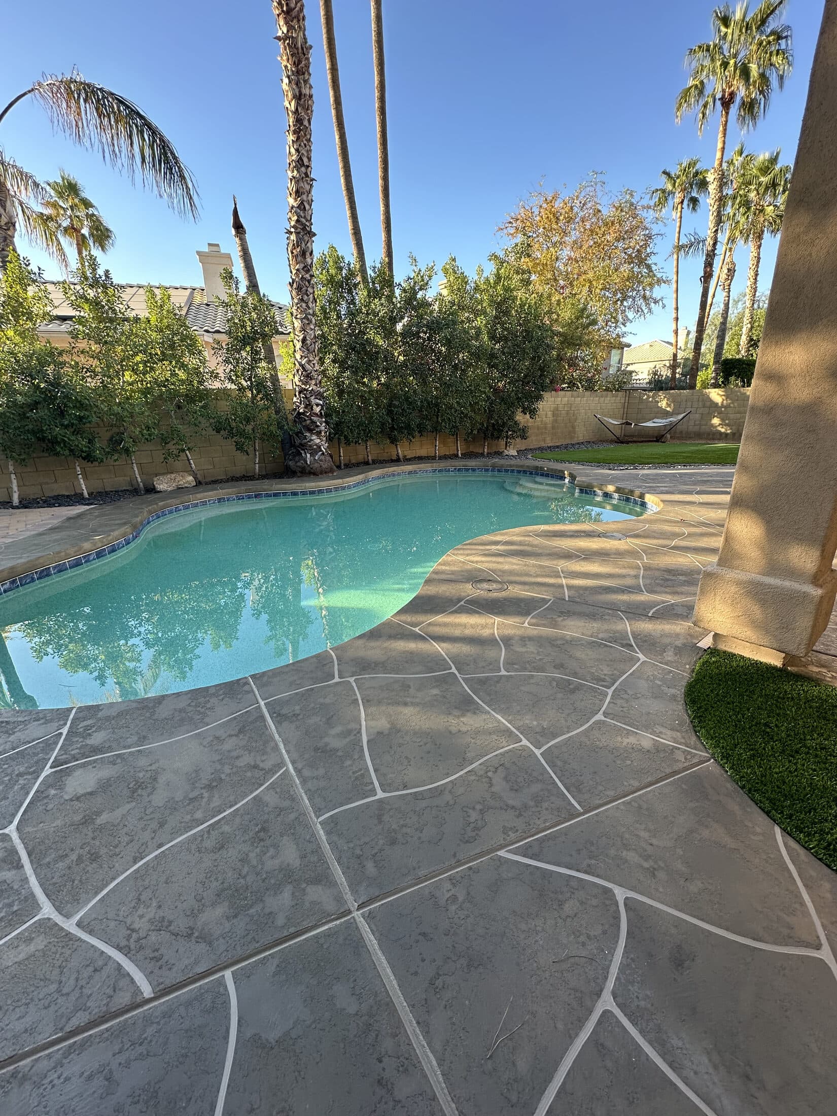 Stamped concrete overlay patio around a backyard pool