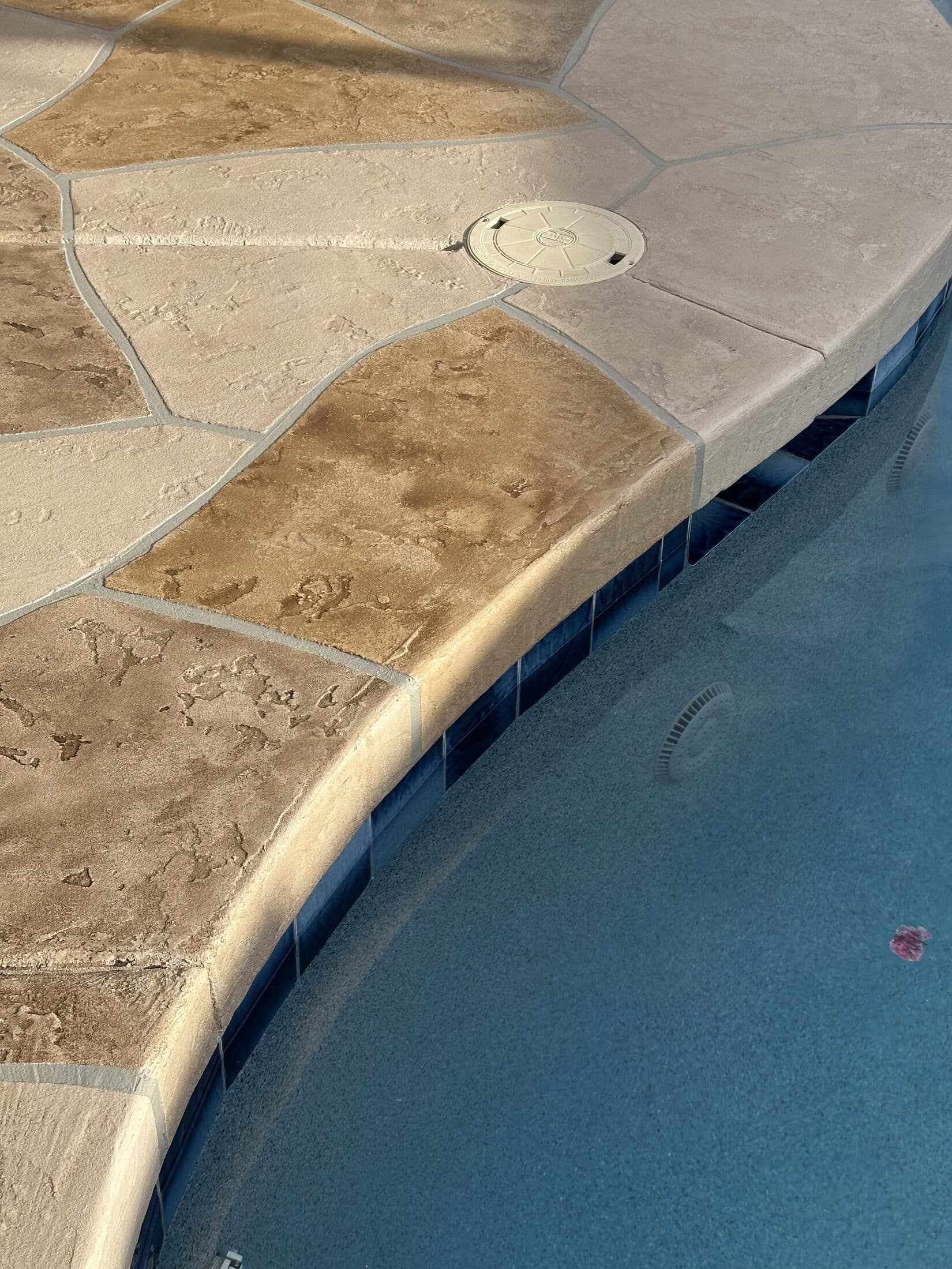 Stamped concrete overlay flagstone-pattern patio around a backyard pool in Phoenix, AZ