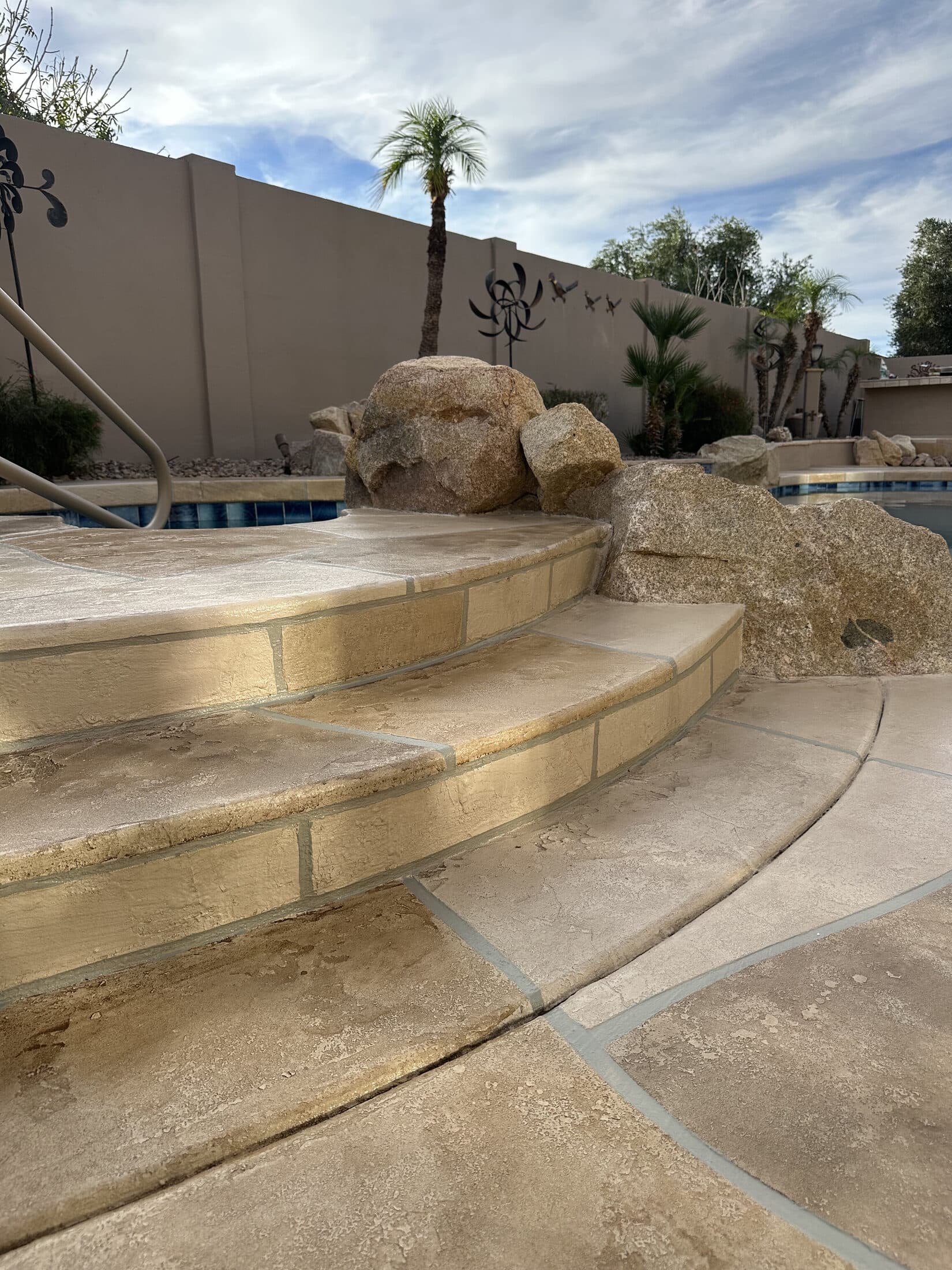Stamped concrete overlay steps with natural boulder accents